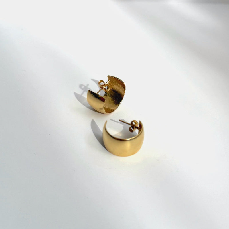 Gold chunky hoop earrings on a white background